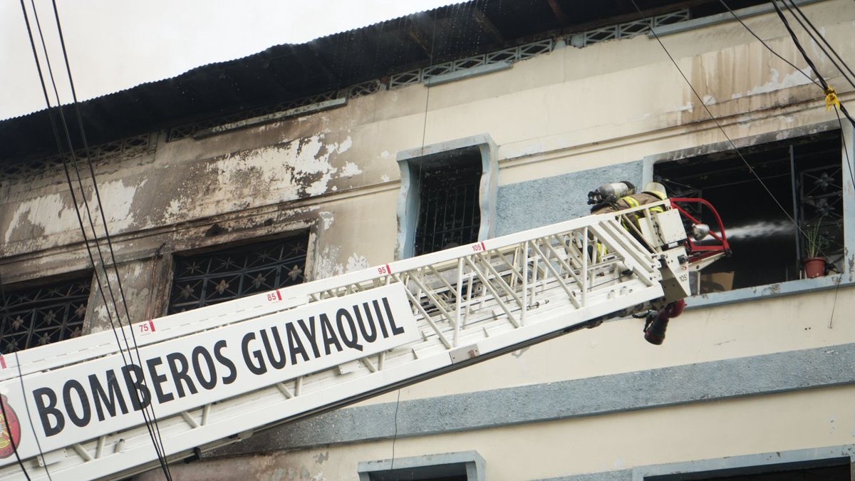 BomberosGYE's tweet photo. Al momento, 19 unidades del #BCBG colaboran  para el control de la emergencia. 

Debido al colapso parcial de una escalera de madera en el interior de la estructura, las operaciones continúan desde el exterior. Se trabaja con tres líneas en la parte inferior y un camión escalera. https://t.co/HLnAUrFLSS
