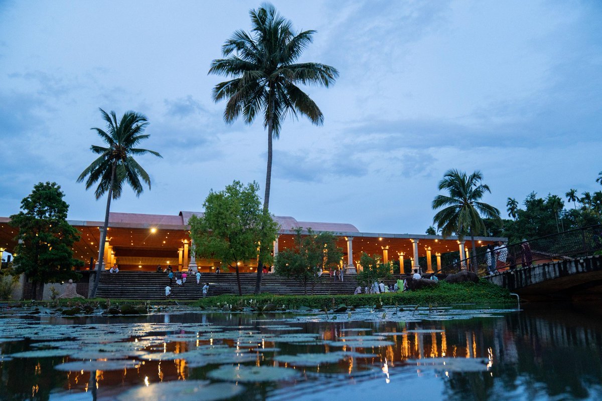 As twilight descends, the lights of the Yoga center find a quiet reflection in the still waters of the lily pond.