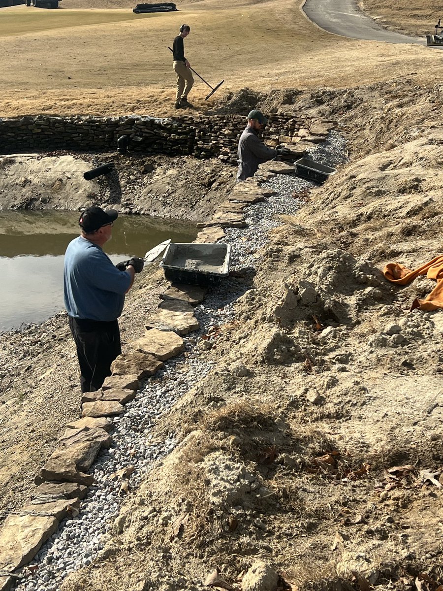 riverridgegolf's tweet photo. Last step on the inside of dry stack wall on 16 pond. Cementing the top layer. Notice the reused pipe and Christmas tree for fish cover. Stocking fish in a month. 17 pallets, 34 tons rock, one by one. Installed during winter 2024-25 and 2025-2026. https://t.co/BqcDXMBxVf