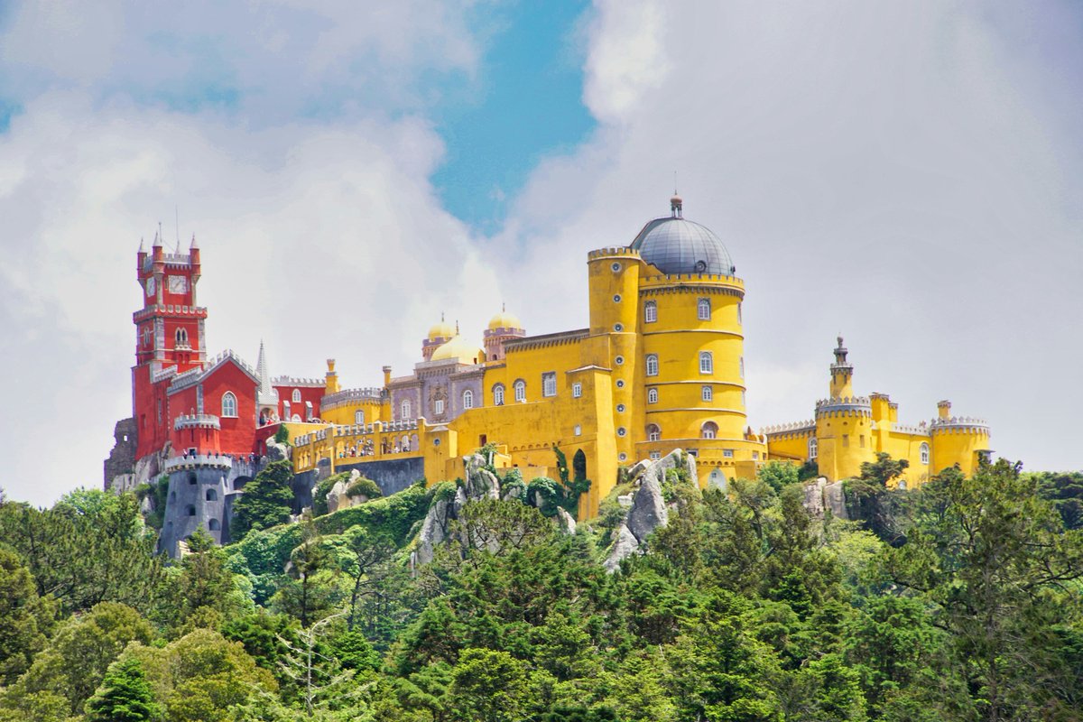 alentejo_1970's tweet image. Pena Palace in #Sintra, #Portugal is one of the world’s best examples of Romanticist architecture, mixing bright colors, domes, and whimsical details! 
Its hilltop location often sits above the clouds, giving it a dreamlike look. 🇵🇹