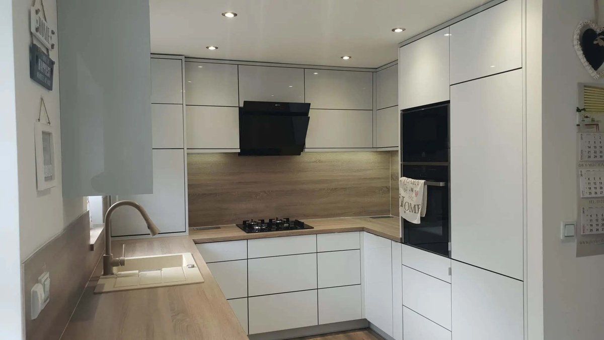 One of our case studies showing bespoke handleless kitchen in Barnsley, built around a clean U shaped layout, high gloss white and grey slab doors, integrated appliances, Blum storage hardware and Bardolino Oak worktops with matching splashbacks.

The goal was to create a modern