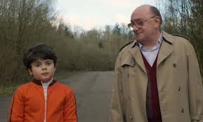 merlinpapin3's tweet photo. Vu le Film #LaCache de Lionel Baier (2025) avec Michel Blanc William Leghbil Dominique Reymond Aurélien Gabrielli Liliane Rovère Ethan Chiementi Larisa Faber Gilles Privat
En mai 1968, Christophe, un garçon de neuf ans, vit chez ses grands-parents, entouré de ses oncles et de son arrière-grand-mère. Ils campent autour d'une mystérieuse cache, révélant peu à peu des secrets de famille.
Avec La Cache, Lionel Baier signe sans doute son film le plus inattendu — presque à contre-emploi. Lui, le cinéaste “queer” libre et piquant de Garçon Stupide ou Un autre homme, s’embarque ici dans un projet à la fois très balisé et étrangement hors-sol : une coproduction Suisse–Luxembourg qui prétend ausculter un moment ultra franco-français, Mai 68. Sur le papier déjà, on sent le léger parfum d’erreur de casting… version production.
L’histoire suit Christophe, 9 ans, gamin rêveur qui observe le monde depuis sa “cache”, un refuge autant physique que mental, où il transforme la réalité en mythologie personnelle. Autour de lui gravite une famille juive que le scénario enferme dans une forme de psychose héritée de la Shoah : peur de sortir, peur de l’extérieur, peur diffuse de tout. L’idée pouvait être forte, mais elle tourne vite à la démonstration appuyée, presque caricaturale — comme si 1968 n’avait rien changé, comme si l’Histoire s’était figée dans l’angoisse.
Et puis il y a cette idée… improbable : Charles de Gaulle qui viendrait se cacher chez eux. Là, on bascule franchement dans le fantasme de scénariste. Non pas un dérapage poétique ou surréaliste assumé, mais plutôt une facilité narrative qui déconnecte encore davantage le film du réel. Une sorte de “et pourquoi pas ?” qui fait surtout lever un sourcil.
La mise en scène, elle, n’aide jamais à faire passer la pilule. Elle est sage, presque scolaire, là où Baier nous avait habitués à plus de nerf et d’ironie. La voix off, omniprésente, finit par devenir fatigante, comme si le film ne faisait jamais confiance à ses images ni à ses acteurs. Tout est expliqué, surligné, répété — au point d’étouffer toute émotion spontanée.
Et pourtant, côté casting, il y avait de quoi faire. Michel Blanc est impeccable, comme souvent, apportant une humanité fragile qui sauve plusieurs scènes. William Lebghil insuffle une énergie bienvenue, plus contemporaine, presque en décalage avec le reste du film. Quant au jeune Ethan Chimienti, il est réellement attendrissant, trouvant un ton juste là où le film hésite sans cesse.
Malgré ces présences solides, on reste à distance. Comme si on assistait à une histoire de famille… sans jamais en faire partie. Le film regarde ses personnages vivre, mais ne nous invite jamais à entrer dans leur intimité. Et c’est peut-être là son plus grand échec.
La Cache donne l’impression d’un film enfermé dans son propre dispositif — une cache, en somme — où ni le contexte historique, ni les enjeux intimes ne parviennent à respirer. Une œuvre qui voulait mêler mémoire, enfance et Histoire, mais qui reste coincée entre les époques, les intentions… et les bonnes idées mal exploitées.
@FredOL69007
❤️si vous aimez