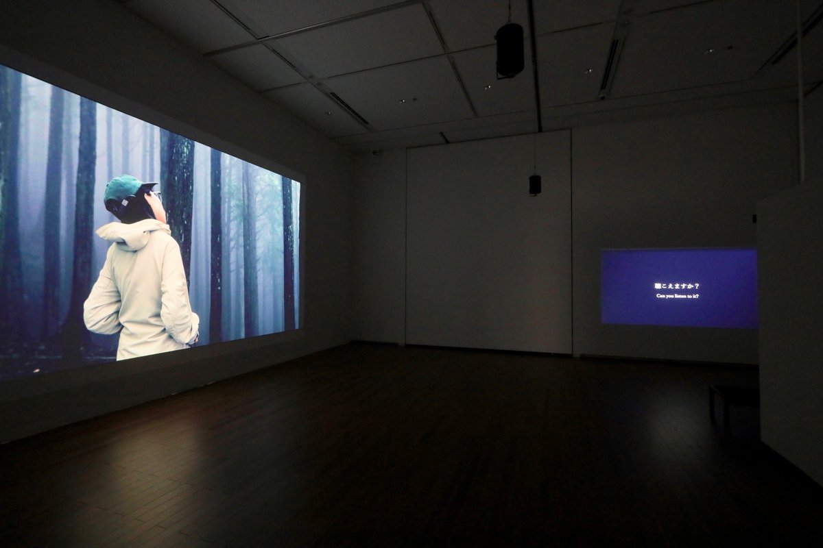 tottori_moa's tweet photo. /／
📣 #CONNEXIONS 展 明日まで！
\＼

『コネクションズ ―接続するアーティストたち』作品紹介

👤mamoru (マモル)
［サウンド・アーティスト、大阪出身］

☞mamoruは、「リスニング／聴くこと」から得られるオルタナティブな世界観を探求する実践者です。その発見を声や語り、歌、文字、字幕、フィールドレコーディング、音楽、映像などを素材として、パフォーマンスやインスタレーションで発表してきました。

《NEVER BE NO VOICE／声を挙げ、絶やさない》は、2021年に始動した「寄り合うこと」と「声」をめぐるリサーチ・プロジェクトです。コロナ禍で「集まること」や「声を出すこと」が制限されるなか、身体的自由の縮減や他者との距離の遠さが顕在化する状況を受け、声がどのように立ち上がり、持続し、変容していくかを探る実験として構想されました。
参加者は呼吸法や発声のエクササイズを通じて「チューニングされた」身体を立ち上げ、即興的に声を響かせます。

本展では、県内8会場で行われたワークショップとセッションの成果を映像サウンド作品として共有しています。

- - - - - - - - - - - - - - - - - - - - - - - - - - -
『CONNEXIONS｜コネクションズ
　―接続するアーティストたち』

〈会期〉2026/2/7㊏～3/22㊐
〈会場〉3F 企画展示室
〈開館時間〉9:00～17:00(入館は16:30まで)
〈観覧料〉一般 1,200円／学生 750円／高校生 500円／小中学生 300円
- - - - - - - - - - - - - - - - - - - - - - - - - - -

▼展覧会ページはこちら
https://t.co/2yhS3Y3wQE

#鳥取県立美術館 #コネクションズ #企画展 #mamoru