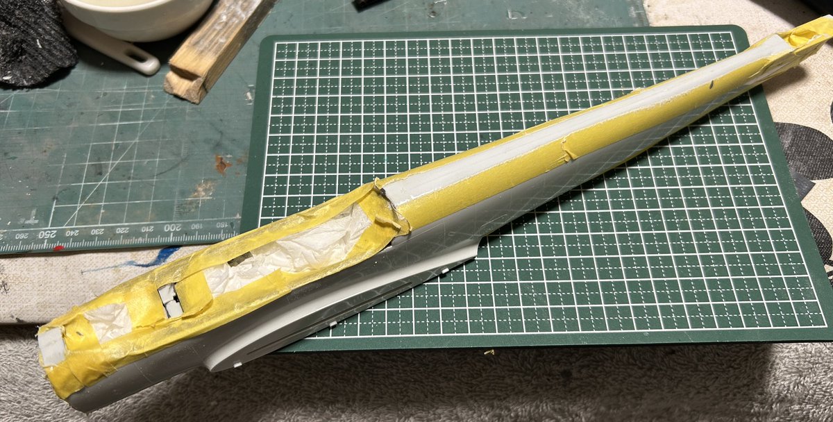 mack_tou21295's tweet photo. 胴体・主翼・尾翼などの合わせパーツを接着、飛行機プラモでは定番作業となる合わせ目消し、マスキングテープでこれ以上は削らない、というラインを決めてます
主翼はパーツが歪んでたのでドライヤーで修正、写真は修正後です
レベル旧1/32は凸リベットだらけが多いけど、コチラのBf110はほぼないです https://t.co/xIma2Mg1xO