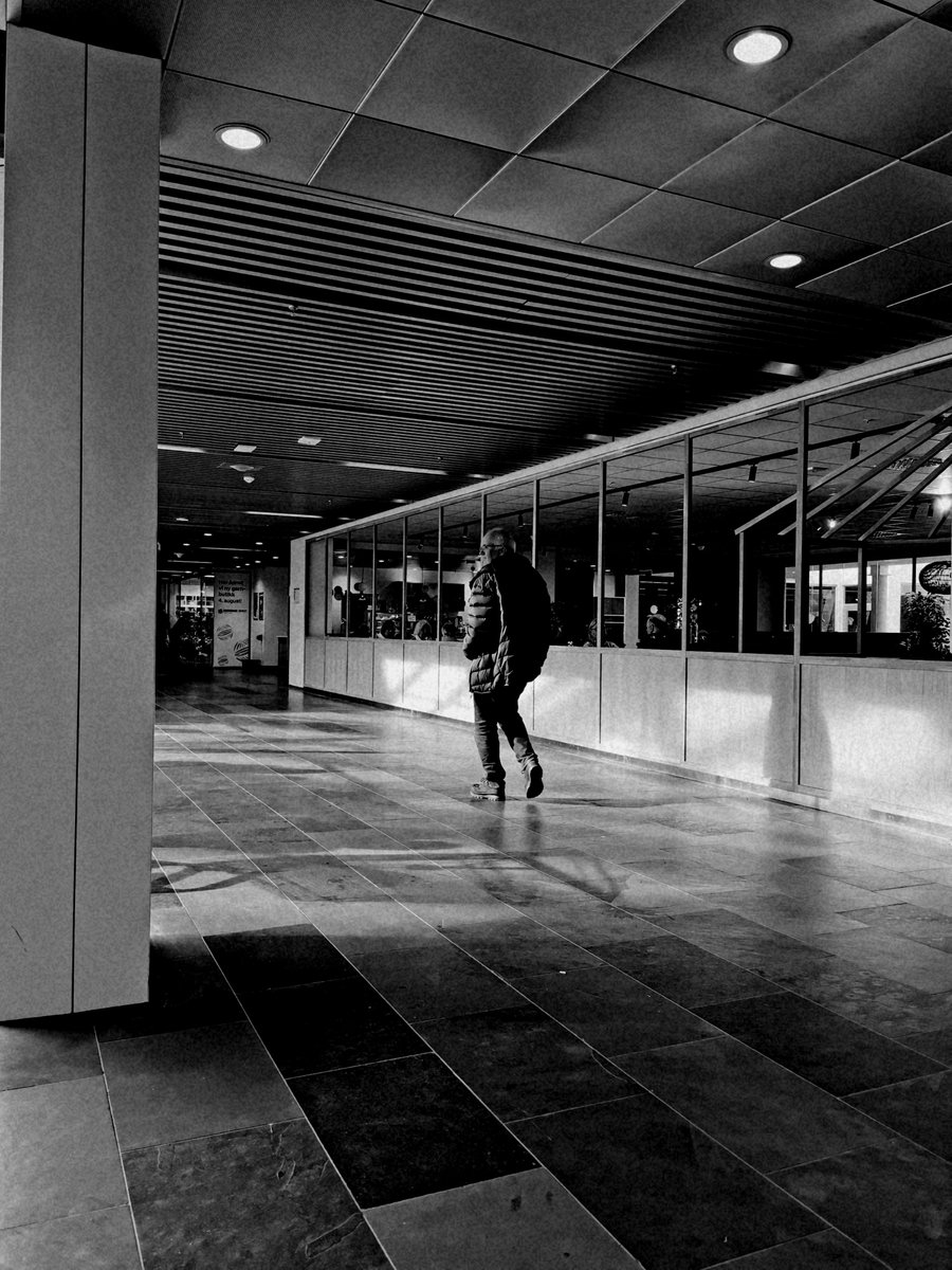 The old man wandering aimlessly through the empty shopping mall