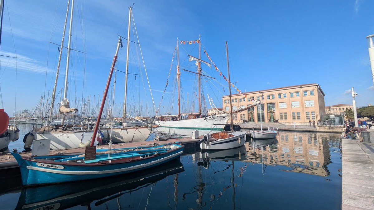 isad125's tweet photo. Au port de Toulon, on voit une goélette traditionnelle, un voilier ancien à deux mâts, amarré à quai. Les mâts sont hauts, entourés de nombreux cordages, et l’ambiance du port est à la fois animée et paisible, avec le clapotis de l’eau et les silhouettes des marins. https://t.co/aoz3qj7IDG