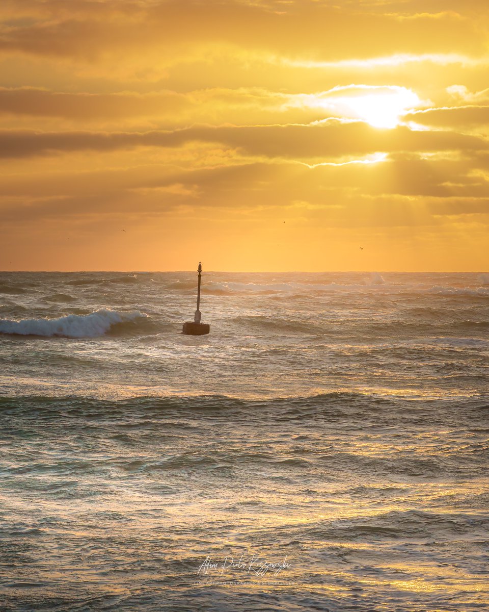 apkossowski's tweet photo. Golden sunrise over Arniston’s fishing landing in the Western Cape, with the beacon silhouetted against dramatic clouds and textured waves rolling across the early morning sea.

#arniston #southafrica #sunrise https://t.co/QIHJdkhXHc
