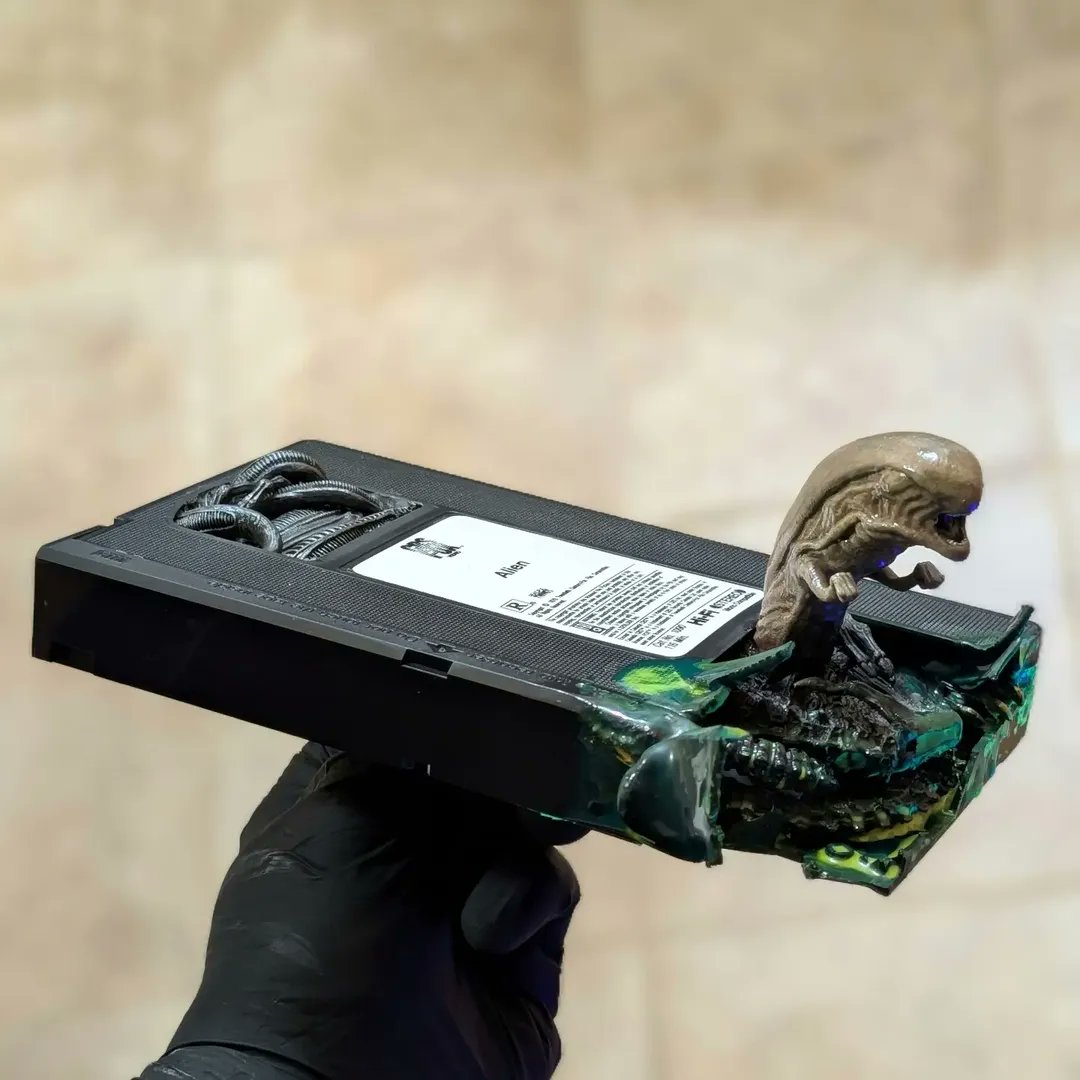 avpgalaxy's tweet image. It doesn't take much xenobiological knowledge to know there's something peculiar going on with this particular copy of an Alien VHS! This fantastic sculpture is the work of Adam Perocchi! #Xenomorph #Alien #AdamPerocchi #Aliens #XenomorphXX121 #AlienRomulus #AlienEarth