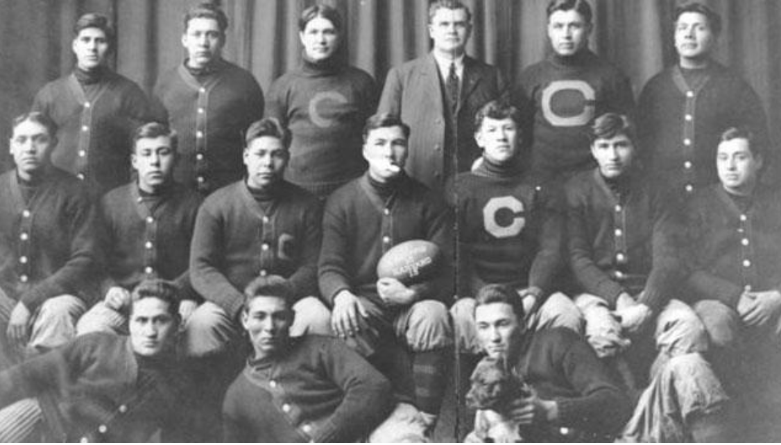HistColFootball's tweet image. On Nov 11, 1911, The Carlisle Indian Industrial School upset Harvard, 18-15, in front of 25,000 fans in Cambridge, Massachusetts. (Team Photo: Pop Warner standing 3rd from right &amp;amp; Jim Thorpe seated 3rd from right.) #CollegeFootball @ClintKPoppe