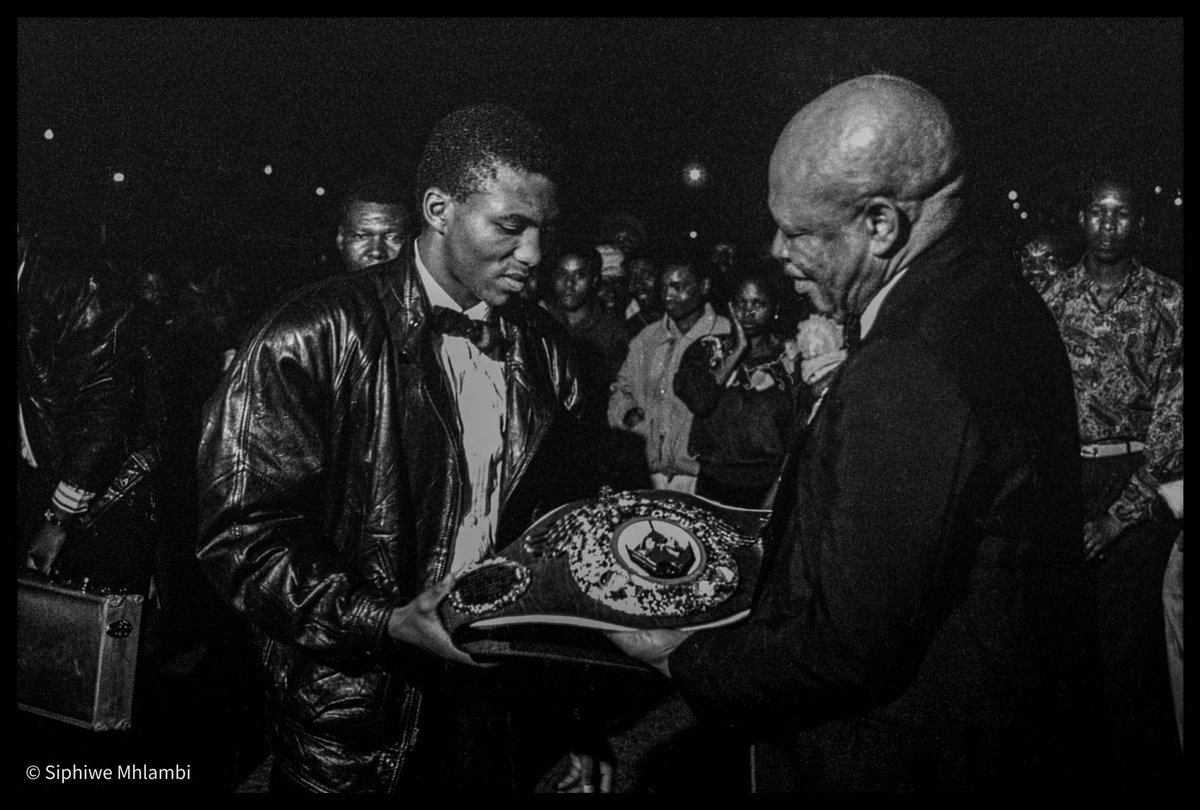 HistorySAZAR's tweet photo. 1990: Dingaan "The Rose of Soweto" Thobela poses with Godfrey "Godfather of Soweto" Moloi after winning the WBO lightweight title by defeating American boxer Tony Lopez. Credit: @sphiwemhlambi https://t.co/5E38jQ6F8d
