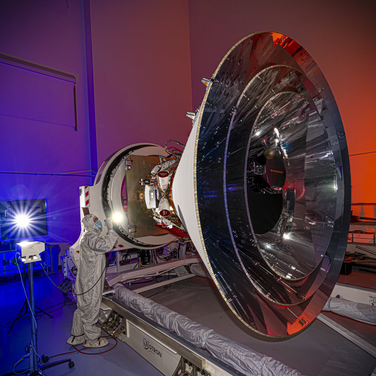 SPHEREx spacecraft in orbit, with an infrared map of the sky in the background.