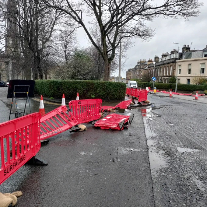Closed junction with overturned / scattered barriers, cones etc. across the pavement