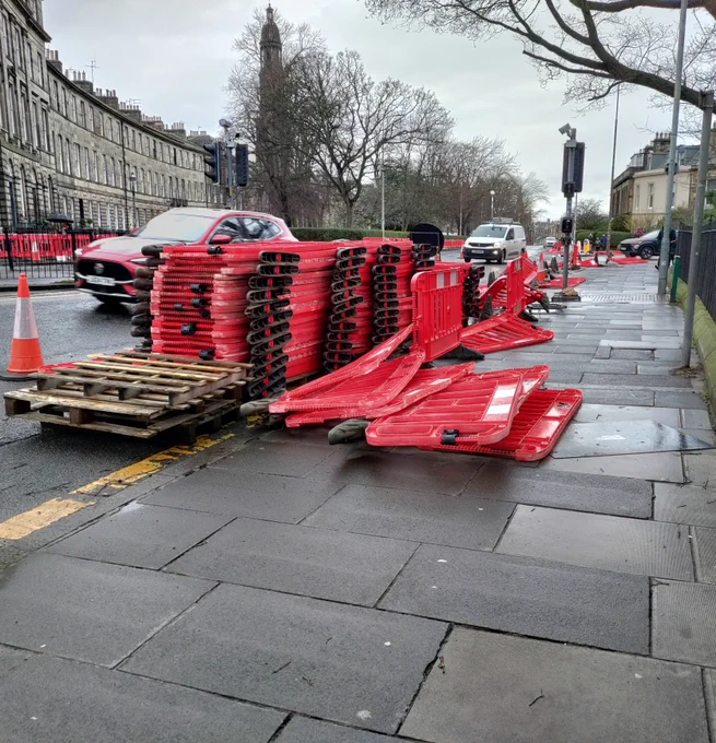 Poorly stored road barriers spilling over the pavement impacting access.