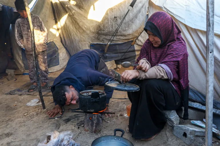 🚨 Only 1.5% of Gaza families can cook with gas. 54% burn wood and 43% burn plastic and waste. Islam Dardouna, an asthma patient, cooks over open fire daily — her inhaler in one hand, a pot in the other. Her one-year-old neighbor's chest hurts constantly from inhaling the smoke.
