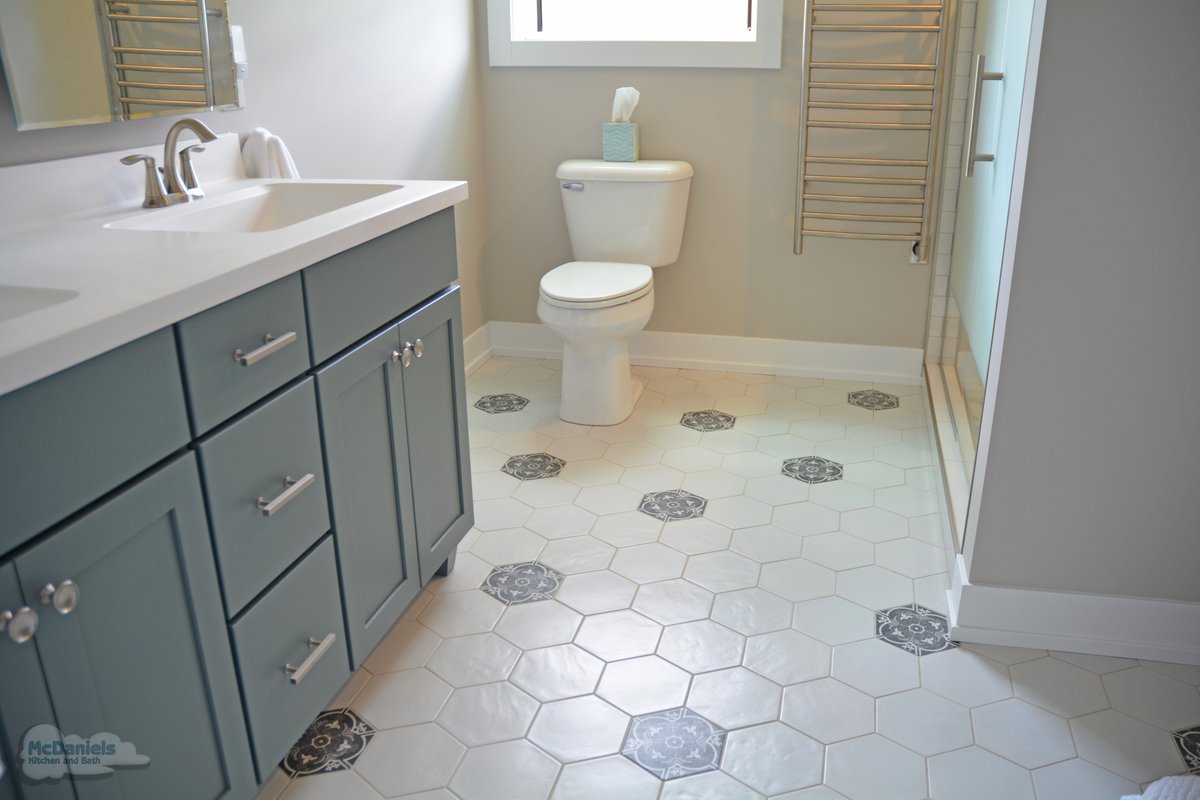 Hall bathrooms need to balance style and function for both family and guests. ✨ This design features a stylish vanity, a spacious shower with a pebble tile floor, and an eye-catching tile pattern that makes the space stand out. 🚿