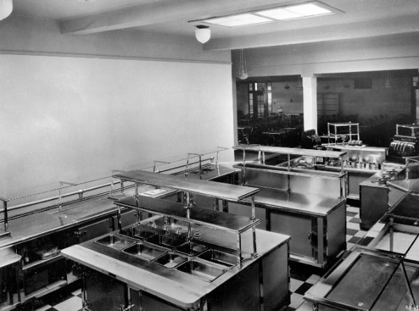 FDP_DesignPros's tweet photo. A look back at front-of-house cafeteria design from the archives! The stainless-steel serving counters, glass sneeze guards, Art Deco paneling, and checkered floors speak to an era when craftsmanship and detail were built right into the equipment itself. https://t.co/KMxghdy6Qd