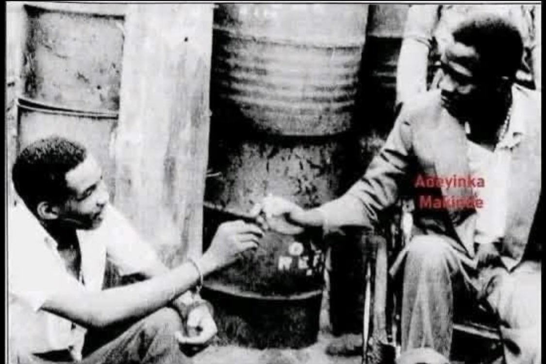 THE LAST SMOKE BEFORE THE BULLETS 

Benin City, Nigeria 
March 29,1987

Dreaded armed robber, Lawrence Anini  (in a wheelchair,right) and his gang mate, Monday Osunbor, take the last puff of a cigarette before facing the firing squad.