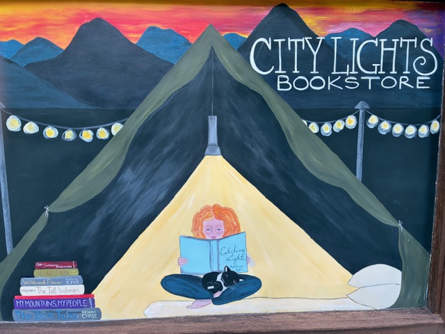 On a recent trip to TN, I stopped at the fabulous City Lights bookstore in Sylva, NC. Loved this mural on the side of the building. The black and white store cat named Cedric is represented! Also, the door of their break room is covered with bookmarks from independent bookstores
