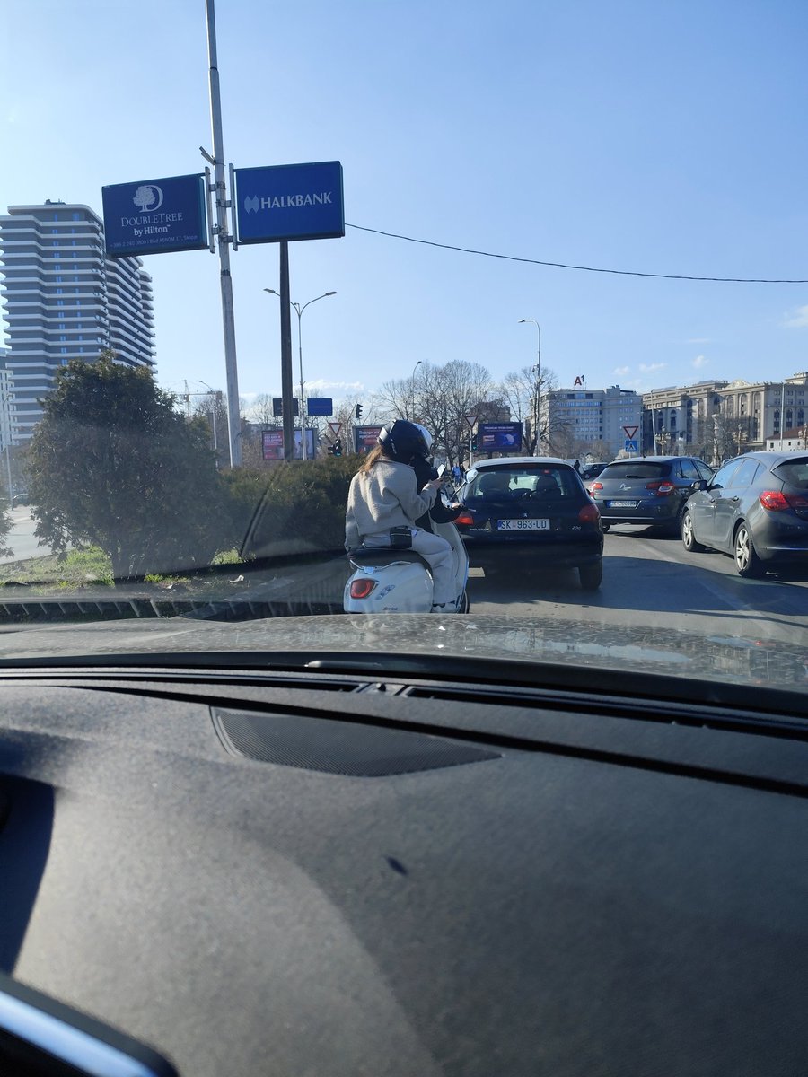 Девојчињава со моторчево се шмугнуваат помеѓу коли. Ќе ги тресне некој што не ги очекува затоа што одат цик-цак, таа позади и на мобилен си пишува. Ако некој ги препознае, најдругарски да им каже дека со вакво возење ризикуваат некој џип да ги смачка и после ќе има плачење.