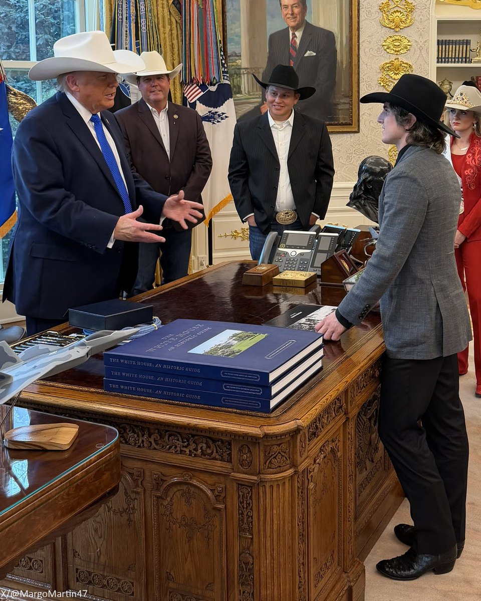NEWSMAX's tweet photo. WATCH: President Trump puts on a cowboy hat in the Oval Office with the National Finals Rodeo winners. https://t.co/paUv9krvGO