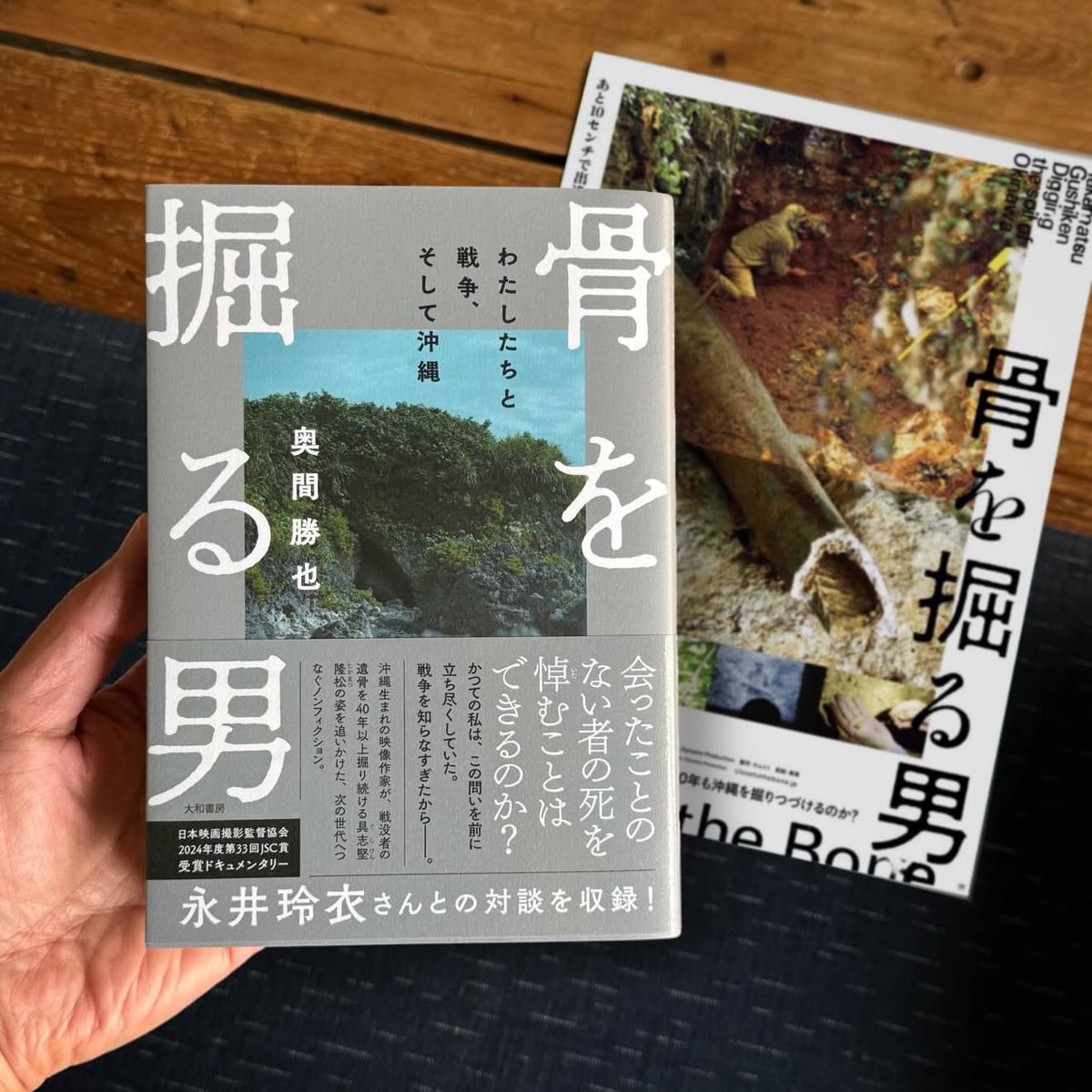 2024年に公開された映画「骨を掘る男」は、沖縄で40年に渡り戦没者の遺骨を掘り続ける、具志堅隆松氏の姿を追ったドキュメンタリーでした。
こちらの最新刊『骨を掘る男』は、その監督である奥間勝也氏が、映画制作の過程とそれに伴う思索の変遷を綴ったノンフィクションです。続く→