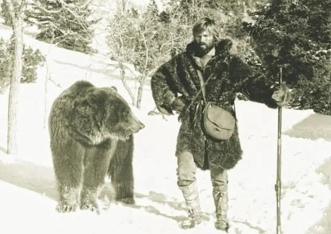 Dr_TheHistories's tweet photo. In 1972, ‘Jeremiah Johnson’ was voted the best mountain movie ever. This photo shows actor Robert Redford standing next to a Grizzly.... 

Released in 1972, Jeremiah Johnson became one of the defining “mountain man” films in American cinema. Starring Robert Redford, the story follows a Mexican-American War veteran who retreats into the Rocky Mountains to live as a trapper and gradually becomes a legendary frontiersman. Directed by Sydney Pollack, the film was based partly on the real 19th-century mountain man John Jeremiah Johnson, also known as “Liver-Eating Johnson.”

Much of the movie was filmed in the rugged landscapes of Utah’s Wasatch Mountains, the Uinta Mountains, and parts of Arizona, giving the film an unusually authentic wilderness feel. The production relied heavily on natural light, minimal dialogue, and long silent sequences showing survival skills like trapping, tracking, and winter travel, elements that helped give the film its quiet, mythic tone.

When it premiered at the 1972 Cannes Film Festival, the film received a standing ovation and later became a cult classic among outdoor enthusiasts, helping inspire a renewed fascination with America’s mountain-man era.

© History Pictures

#drthehistories