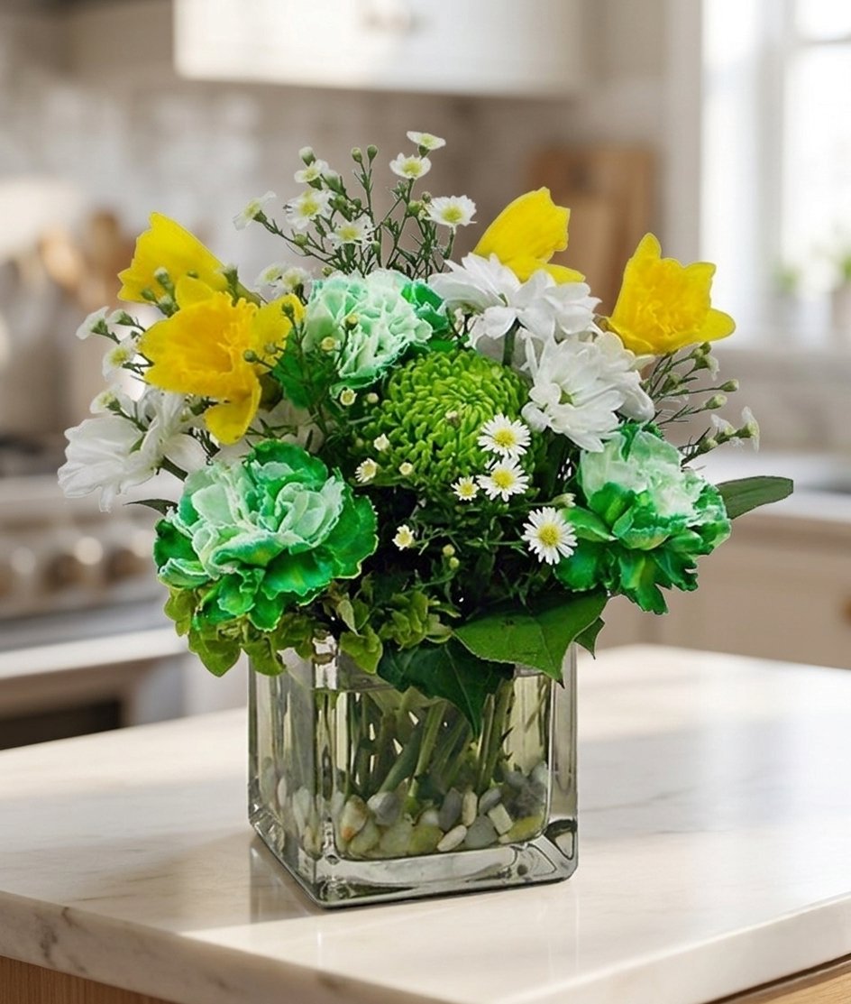 Stevesflowers's tweet image. Send a bit of luck with our "Top O' The Mornin'" ! ☘️🌾

This mix features green carnations, daffodils, &amp;amp; mums in a cube vase with river rock. It’s the perfect way to share St. Patrick’s Day wishes!🍀

#StPatricksDay #FloralDesign #LuckyBlooms #GreenwoodFlorist #StevesFlowers