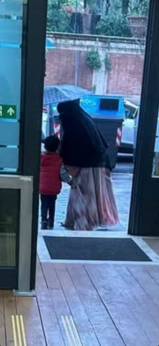 AzzurraBarbuto's tweet photo. Roma, Occidente libero. Questa donna è entrata in banca, ossia all’interno di un ufficio pubblico, completamente travisata, ovvero indossando il velo integrale. Questa condotta è illegale, poiché contraria alle norme sulla pubblica sicurezza e alle norme antiterrorismo. Perché lo accettiamo? Perché non protestiamo? Perché nessuno l’ha invitata ad uscire dall’ufficio? Perché la polizia non la ferma per identificarla? Perché tolleriamo che le nostre regole vengano calpestate? Perché consideriamo la sicurezza qualcosa di scarso valore e siamo disposti a rinunciarvi? Perché abbiamo paura? E di cosa? Di essere giudicati islamofobi? Di apparire poco politicamente corretti? 
Questo nostro atteggiamento ci rende deboli, scoperti, esposti ad ogni genere di pericolo, perché sotto quegli indumenti può nascondersi chiunque e può nascondere qualunque cosa, armi incluse.
Queste immagini mi sono state girate da una gentilissima utente dí Instagram, che era presente in questo ufficio e che, quando ha fatto notare questa anomalia, si è sentita rispondere che il personale era in imbarazzo e non è intervenuto per questo. Imbarazzo? Imbarazzante è restare in silenzio.