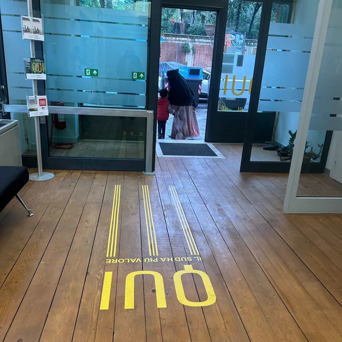 AzzurraBarbuto's tweet photo. Roma, Occidente libero. Questa donna è entrata in banca, ossia all’interno di un ufficio pubblico, completamente travisata, ovvero indossando il velo integrale. Questa condotta è illegale, poiché contraria alle norme sulla pubblica sicurezza e alle norme antiterrorismo. Perché lo accettiamo? Perché non protestiamo? Perché nessuno l’ha invitata ad uscire dall’ufficio? Perché la polizia non la ferma per identificarla? Perché tolleriamo che le nostre regole vengano calpestate? Perché consideriamo la sicurezza qualcosa di scarso valore e siamo disposti a rinunciarvi? Perché abbiamo paura? E di cosa? Di essere giudicati islamofobi? Di apparire poco politicamente corretti? 
Questo nostro atteggiamento ci rende deboli, scoperti, esposti ad ogni genere di pericolo, perché sotto quegli indumenti può nascondersi chiunque e può nascondere qualunque cosa, armi incluse.
Queste immagini mi sono state girate da una gentilissima utente dí Instagram, che era presente in questo ufficio e che, quando ha fatto notare questa anomalia, si è sentita rispondere che il personale era in imbarazzo e non è intervenuto per questo. Imbarazzo? Imbarazzante è restare in silenzio.