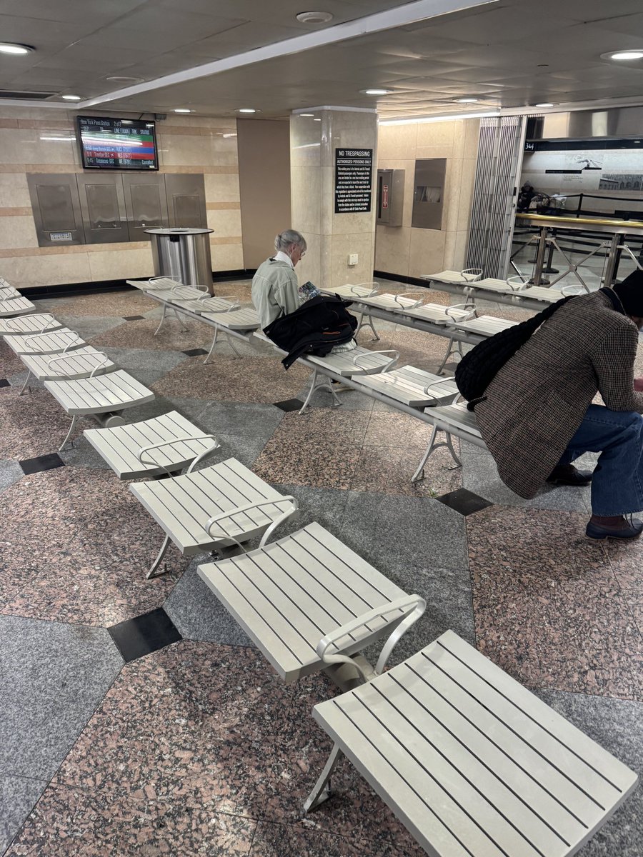 Waiting area for nj transit at Penn station for ticketed passengers. No seat backs. Imagine an airport waiting area w seats w no backs.