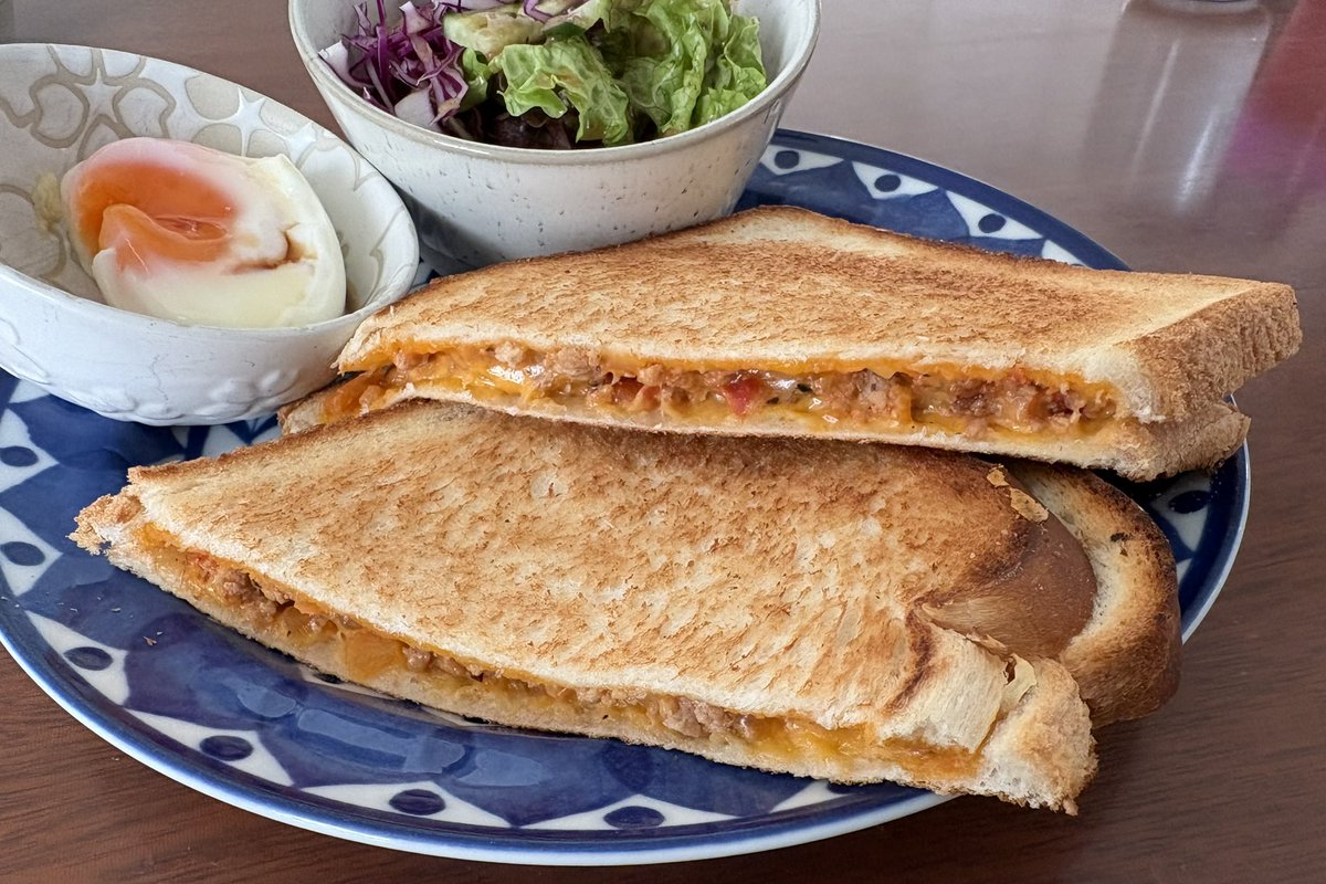 おはようございます。日曜日の朝です。
チーズトースト、完成！

・フライパンでじっくりと。
・チーズを贅沢に充填。
・出来上がり😋

サラダと半熟卵で彩りも完璧👌