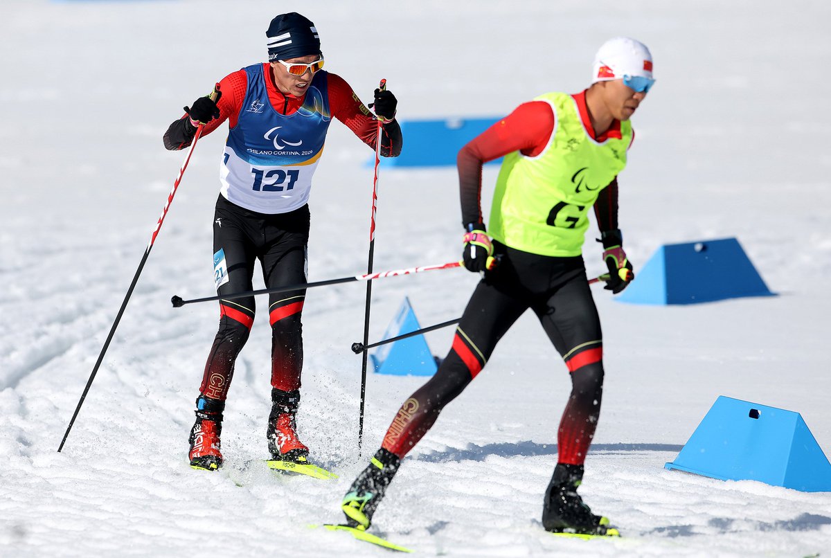 CGTNOfficial's tweet photo. #TheFaces: The unbreakable bond between athlete and guide at #MilanoCortina2026
At the 2026 Milano Cortina #WinterParalympics, some of the most remarkable competitors race not alone, but in pairs. Visually impaired athletes take to the snow alongside their guides, forming a unique partnership built on trust, precision and constant communication.
In Para alpine skiing, a guide skis ahead of an athlete and relay course information through headsets. Before the race, the pair reviews the route together and mentally runs through the course, building rhythm and mutual understanding.
Similar partnerships can also be seen in Para cross-country skiing and Para biathlon. For visually impaired athletes, guides are more than teammates. They are the athletes' eyes on the track, supporting every moment behind the spotlight. #Paralympics