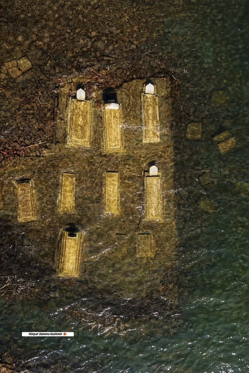 This scene shows graves submerged beneath the waters of the Mangla Dam in Mirpur, Jammu &amp; Kashmir.
When the Mangla Dam was constructed, thousands of homes, settlements and graveyards disappeared under water. Hundreds of thousands of Kashmiris were forced to leave their lands,