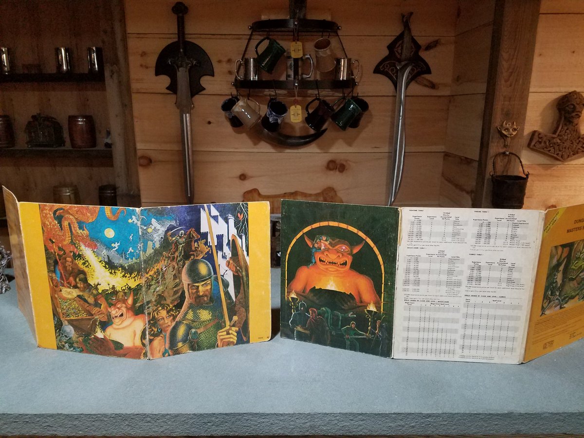 Grand_DM's tweet photo. I’ve used some sort of DM screen since 1983. At first it was just for AD&D charts. Now it’s for minis, handouts, and surprise reveals. Most rolls I make behind the screen, big ones I always do in the open. 

There was a whole phase a few years ago where people treated open rolls and no screen like some enlightened way to GM. It was always just a preference and still is.