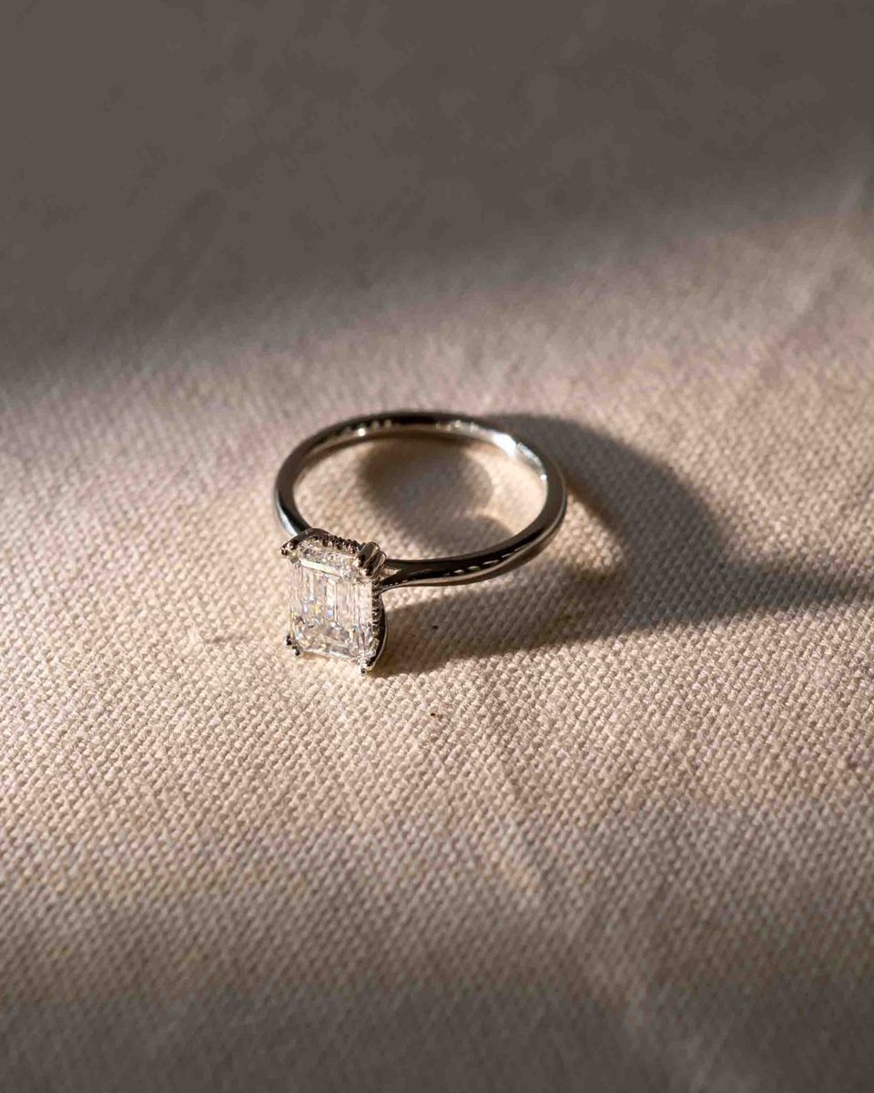 A vivid emerald takes centre stage, with a delicate hidden halo of diamonds beneath the setting. Our Emerald Hidden Halo Engagement Ring is handmade to order, blending clean, modern lines with a subtle layer of brilliance that reveals itself as you move. 

#engagementringinspo