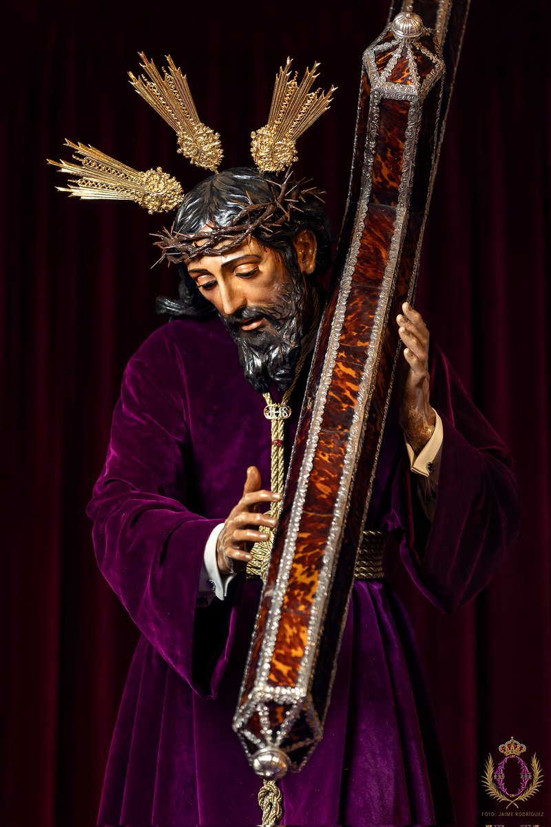 hermandaddelao's tweet photo. La bendita imagen de Nuestro Padre Jesús Nazareno ya está dispuesta para la estación de penitencia del próximo Viernes Santo.  

El Señor aparece ataviado con túnica de terciopelo morado lisa, cordón de hilo de oro trenzado. Sobre el cordón se han colocado un pasador de oro con el anagrama JHS y una sortija con una piedra preciosa. Los puños del camisón llevan igualmente pasadores de plata con una piedra morada. Igualmente, sobre el cordón se ha prendido una corneta de plata dorada en miniatura en conmemoración del L aniversario de @bandasol que desde 1985 acompaña musicalmente al paso del Señor.  Sobre las sienes del Señor se ciñe la nueva corona de espinas realizada por @Laetaresacro y que ha sido estrenada en el Solemne Quinario de este año.  Las potencias de plata labrada y la cruz de carey y plata completan la iconografía del Señor sólo a la espera del adorno floral del paso para el Viernes Santo. 

Dios Humanado, danos piadoso la Salvación. Te rogamos por todos los enfermos y también por las personas que amorosamente los cuidan, como tú cuidas de todos nosotros.

📷 @jaimerfz