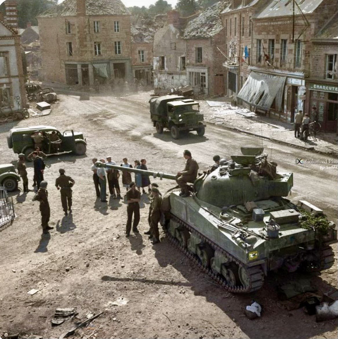 TheWorldatWar2's tweet image. A British Sherman Firefly and other vehicles await new orders in the village of Putanges, Normandy - 20th Aug 1944 #tank #sherman #firefly #putanges #france #normandy #history
