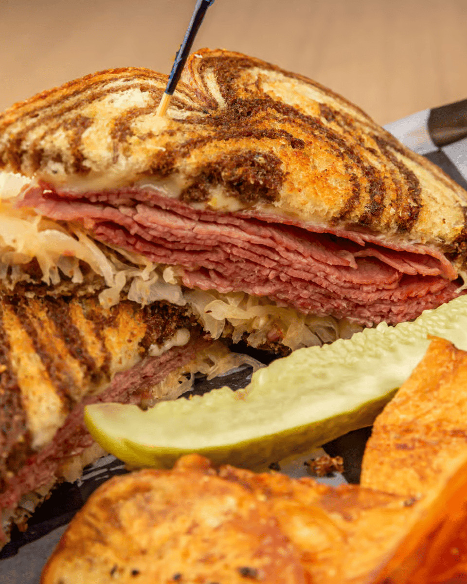 Celebrate St. Patrick's Day ☘️ with a Classic Reuben! Fresh corned beef, melted Swiss, tangy sauerkraut, and our special sauce on rye—crafted with you in mind. Pair it with a drink from our bar to make this St. Patrick's Day one to remember! gaslightpizza.com