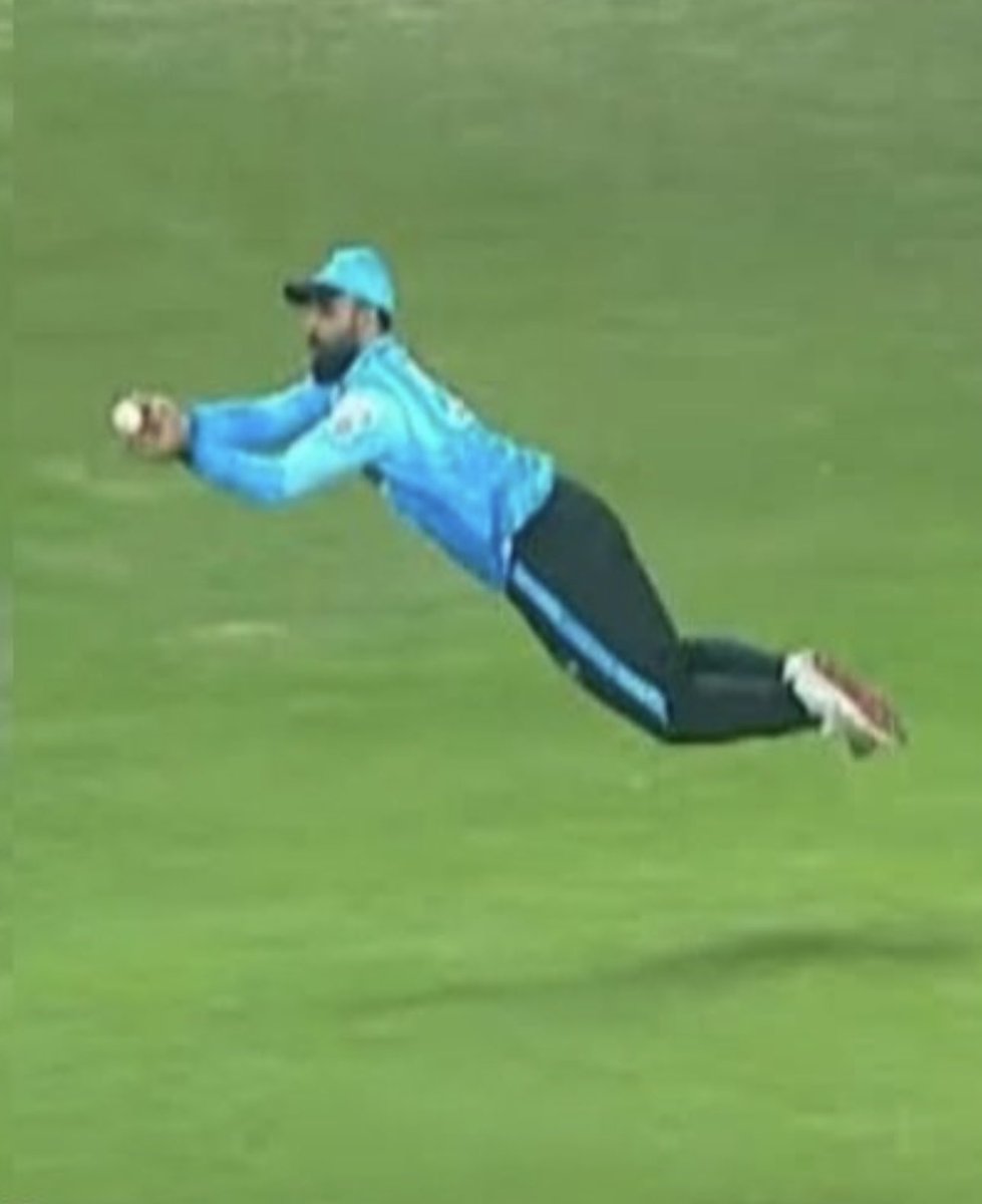 DrNaumanNiaz's tweet photo. Aaqib Javed had informed the press that Fakhar Zaman was injured and therefore not taken to Bangladesh. Within 48 hours, however, Fakhar was captaining Abbottabad in the National T20 tournament. 

This naturally aroused public curiosity, and when Fakhar executed a breathtaking catch, it further embarrassed the selection committee, leading to an uproar on social media. 

Former Pakistan player Abdur Rouf Khan, holding masters degree in biomechanics, questioned their judgement. 

Fakhar subsequently responded, attempting to marginalise the controversy by stating that he was not fit for 50-over cricket but was capable of playing in T20s. 

He may well be correct; however, a biomechanical analysis of the catch he executed, as presented below, reveals no meaningful distinction between the physical demands of a 20-over and a 50-over match. It is, fundamentally, a matter of absolute fitness.

In the photograph of the catch, the following is observed:
 A striking example of whole-body coordination, explosive force production, and precise timing.

1. Movement Phases (Kinematics)
a. Read & Reaction Phase
•Visual tracking of the ball (coordination between the eyes and the brain).
•Reaction time is critical, typically around 200 milliseconds.
•Small adjustment steps position the body prior to take-off.
b. Take-off Phase
•Fakhar appears to have planted one foot (the outside leg relative to the direction of the dive).
•Rapid triple extension occurs:
◦Hip extension
◦Knee extension
◦Ankle plantar-flexion
 This sequence generated horizontal propulsion.
c. Flight Phase
•The body became almost fully horizontal.
•The centre of mass followed a projectile trajectory governed by projectile motion.
•The arms extended forward to intercept the ball.
d. Ball Interception
•The hands formed a “cup” to absorb force.
•The elbows flexed slightly to reduce impact stress.
e. Landing Phase
•Impact would have been absorbed through:
◦Forearms
◦Chest/torso
◦Thighs
•Rolling dissipates force and reducing the risk of injury.

2. Muscle Involvement
Lower Body (Power Generation)
•Gluteus maximus primary driver of hip extension (explosive propulsion)
•Quadriceps knee extension
•Gastrocnemius and soleus ankle push-off
•Hamstrings stabilisation and assistance in hip extension
Core (Force Transfer & Stability)
•Rectus abdominis and obliques maintaining body alignment mid-air
•Erector spinae preventing collapse of the trunk
•The core ensuring efficient transfer of force from the legs to the arms
Upper Body (Catch Execution)
•Deltoids elevation of the arms
•Pectoralis major adduction of the arms towards the ball
•Biceps brachii elbow flexion for shock absorption
•Forearm flexors grip strength
•Finger flexors secure the ball

3. Knee Mechanics
•The knee began in flexion and extended rapidly during push-off.
•This was controlled by the quadriceps, with eccentric co-contraction of the hamstrings ensuring joint stability.
•A key risk arises from excessive valgus or rotational stress, which may strain ligaments (e.g., the ACL). Therefore had to be fit on knees taking this stunner.

4. Balance Systems
Static Balance
•Present briefly during the initial stance prior to movement.
•Controlled via:
◦Proprioceptors (joint sensors)
◦The vestibular system
Dynamic Balance
•Predominant throughout this movement.
•Involves maintaining control of the body while:
◦Accelerating
◦Airborne
◦Landing

If he was capable of executing such a catch supported by clear circumstantial, pictorial, and visual evidence, he appeared, by the standard of fitness demonstrated in that moment, sufficiently prepared even for the demands of a five-day Test match let alone 50 overs. 

@iRashidLatif68 @AbdurRoufKhan6