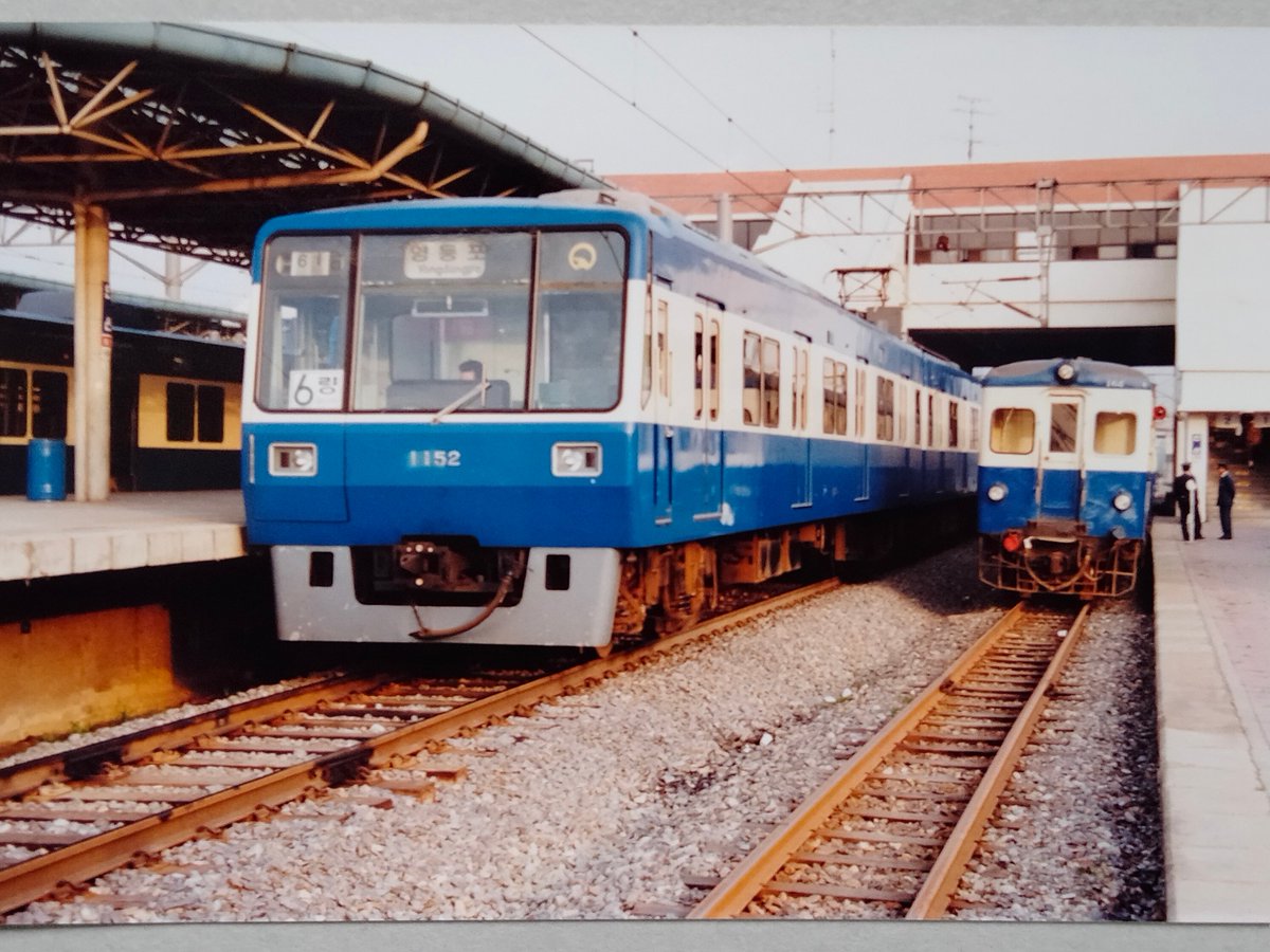 韓国の鉄道

1992年5月5日　安山駅

6時38分に安山に着いた。すぐ隣に前年10月に開業した首都圏電鉄安山線の電車が止まっていて、その大きさ、ナローの小ささがよく分かる。HOゲージとNゲージの車両を並べたようだ。上下列車の交換もあった。

途中の無人駅でも乗降があった→

#韓国の鉄道
