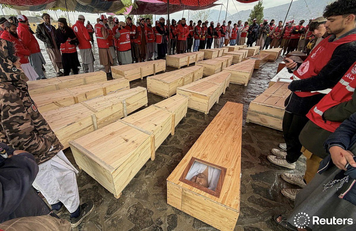 People stand around the coffins of victims, who died in what the Taliban said wa...