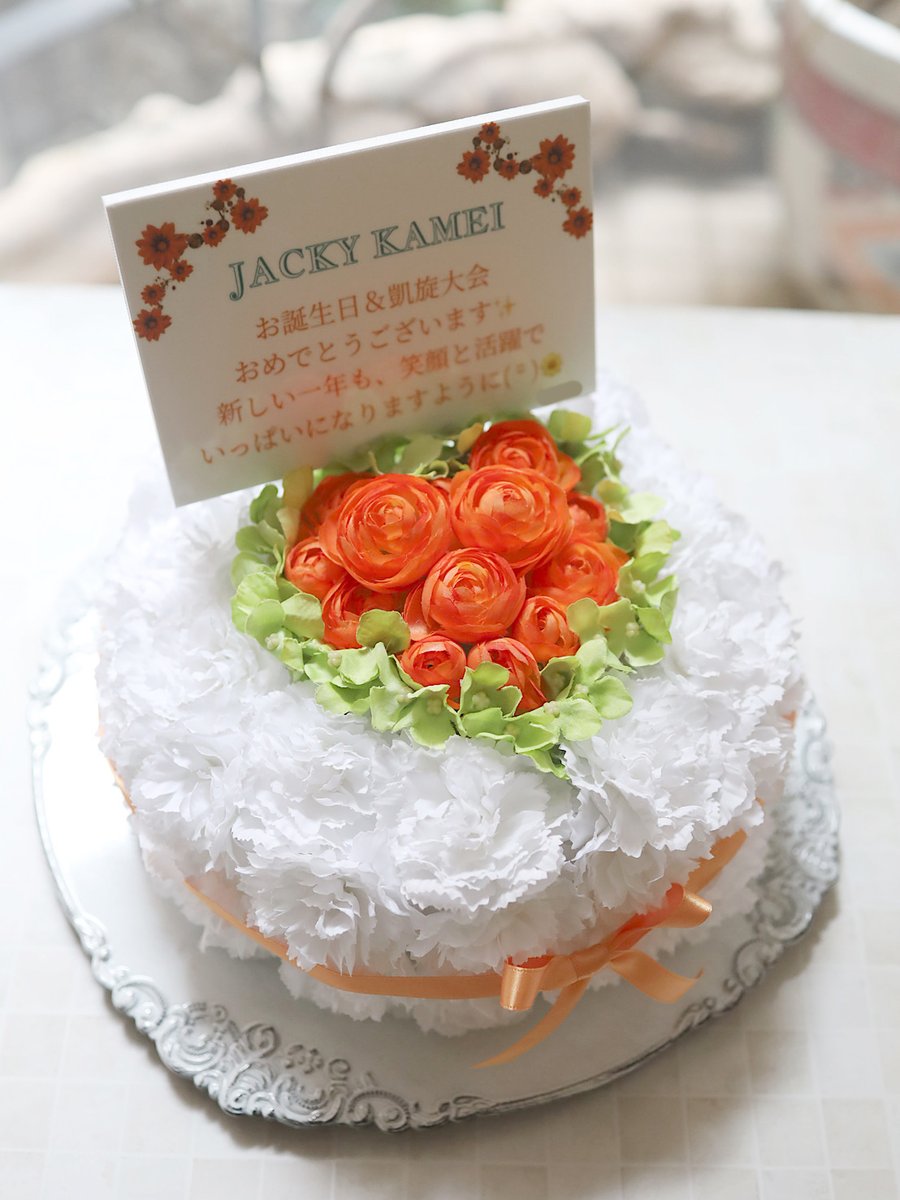 【アーティフィシャルフラワー（造花）のフラワーケーキ】
オレンジのラナンキュラスでハートを作り、緑のアジサイで縁取り。

ご自宅へお届けしお客様ご自身で会場へ運んでいただきました。造花は事前にお届け可能ですし、軽くて持ち運びしやすく、崩れる心配も少ないので、おすすめです。