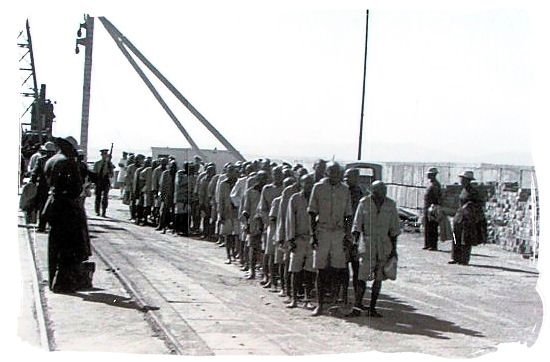 HistorySAZAR's tweet photo. Prisoners after disembarkation, lined up to enter the Robben Island prison, c 1960s. Credit: SAHO Image Archive, Mayibuye Archive https://t.co/ZRXRLBZEXo
