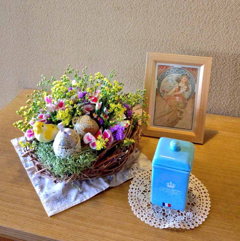 hiroome's tweet photo. 4月の #玄関花 。毎年4月は #イースター をテーマに、何年も前に作ったウサギ耳の自作イースターエッグを飾っていますが、今年は昔、我が家の蔦を編んで作ったカゴを引っ張り出して鳥の巣🪹に見立て、花をいれてみました。ミュシャのポストカードも添えて。#Flowerarrange #easter https://t.co/g5m88Dv7Zg