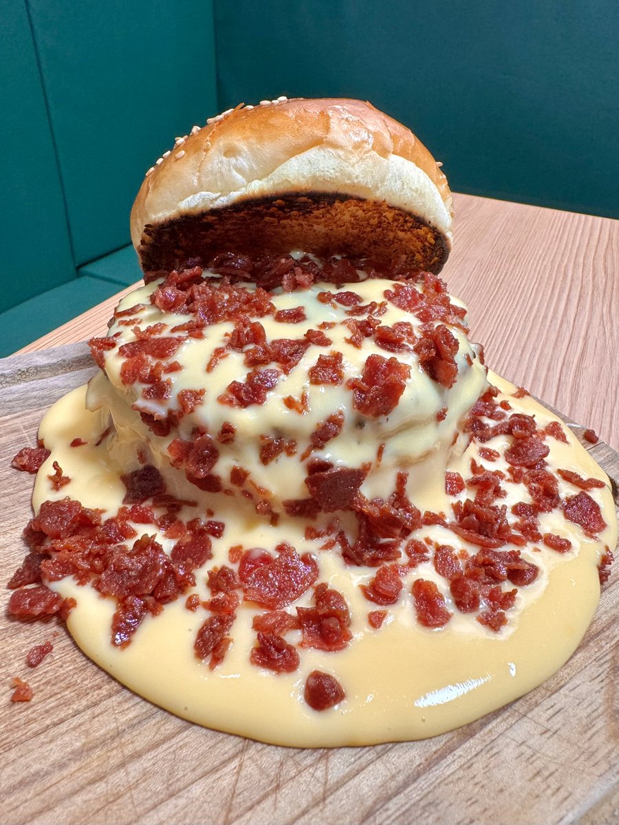 chaminki2's tweet photo. 鶴見線の秘境にポツンと佇む「ブラジル系スーパー」で「カスタカバーガー」食べてきました。バンズはさながら冒険者を待ち受けるミミックの如く大口を開き、濃厚なチェダーチーズクリームが滝のように溢れています。カリカリのベーコンと肉厚・ジューシ���な牛100%パティ、あまりにもワイルド🐦 https://t.co/XYtSyDVFjB