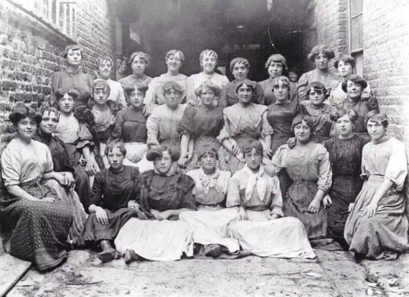 The_East_End's tweet image. Sack and bag making was a fairly common occupation in Victorian and Edwardian London, invariably carried out by women. Here we see a fabulous collection of hairstyles on the sack making girls of Brick Lane C1906 #eastend #hairstyle #fashion the-east-end.co.uk