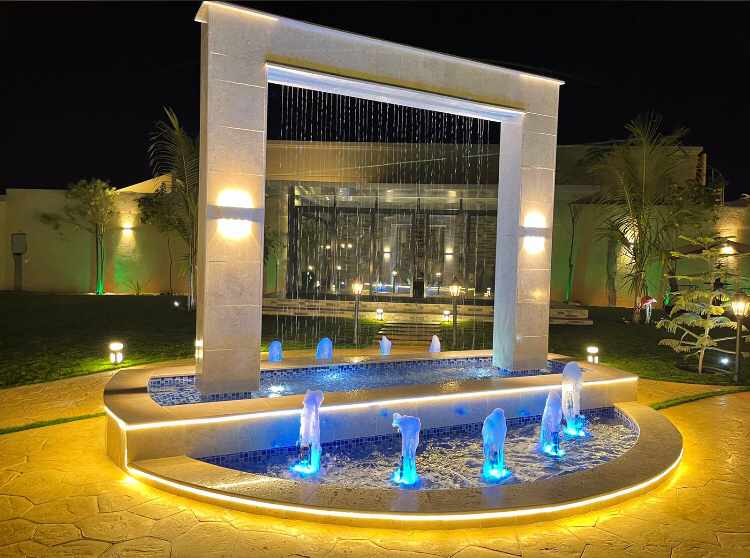 Installation of a linear water feature fountain equipped with nozzles and control valves, designed to create decorative water displays in outdoor landscaping or patio areas.