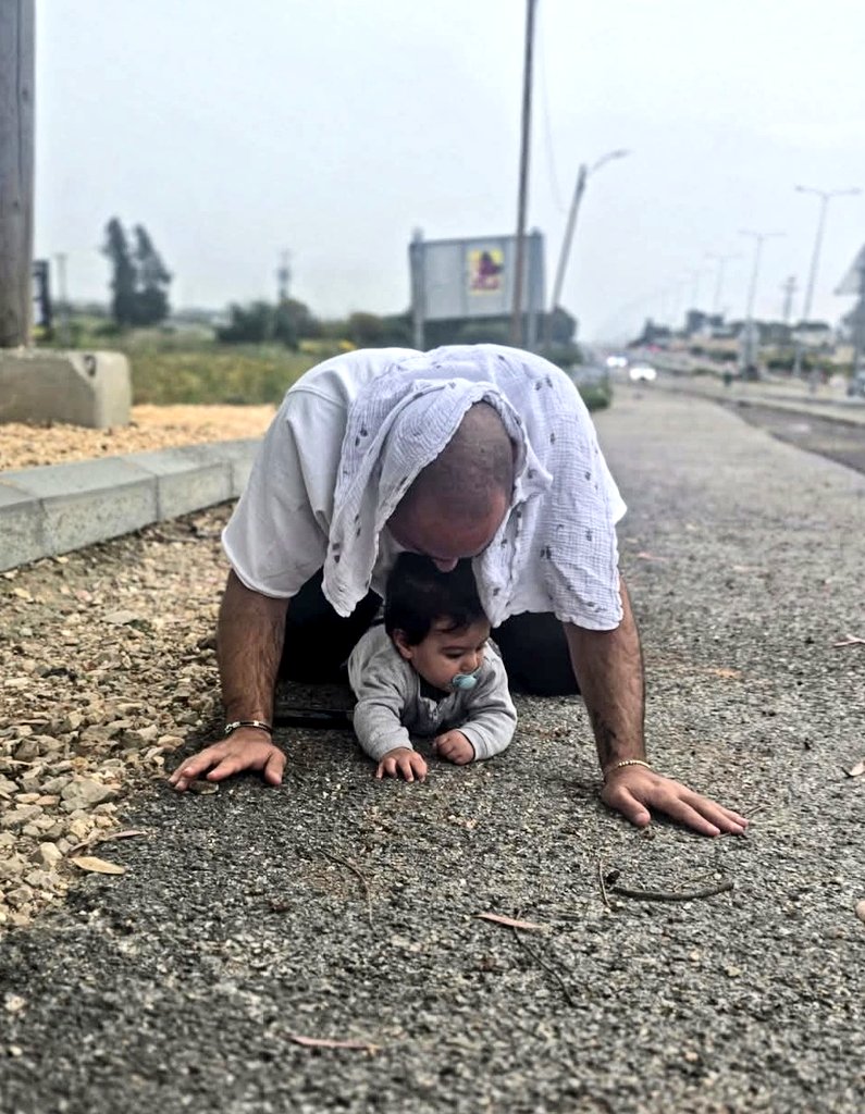 AmbMeron's tweet photo. Israeli reality: While driving to the family traditional Passover Seder, Yossi heard the alarm indicating an incoming enemy missile was on the way. He got out of his car and covered his baby son with his body, to protect him from the attack. Credit: @N12News https://t.co/9aGyKfqAhN