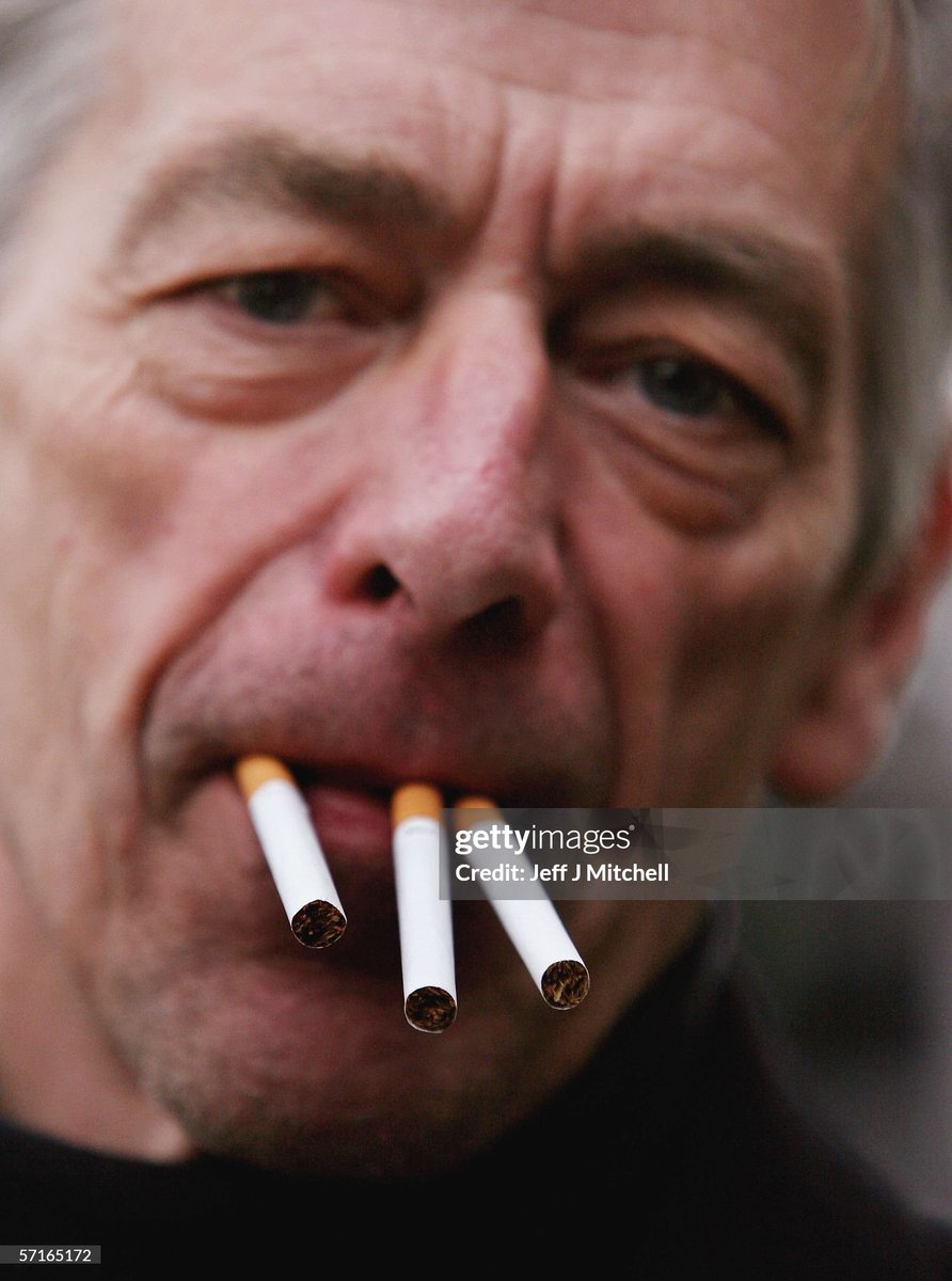 A man puts three cigarettes in his mouth outside the Oran Mor pub in Glasgow, Scotland (2006)