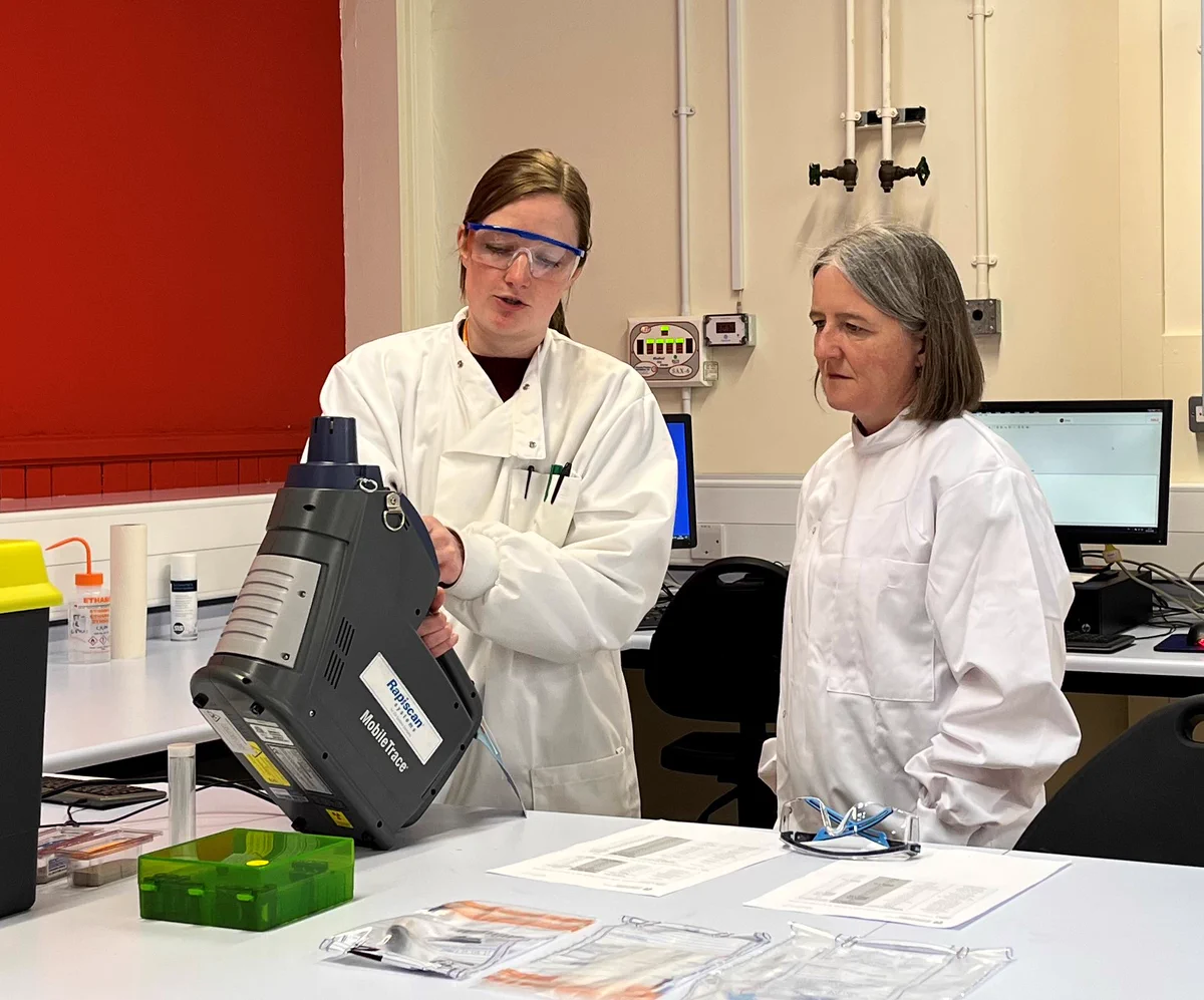 Drugs and Alcohol Policy Minister Maree Todd and a Leverhulme Research Centre for Forensic Science staff member wearing white lab coats, looking at equipment in a laboratory.  
